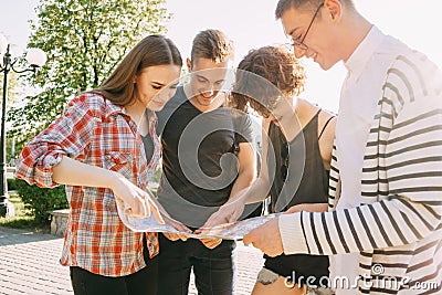 Group of friends searching location on city map. Stock Photo