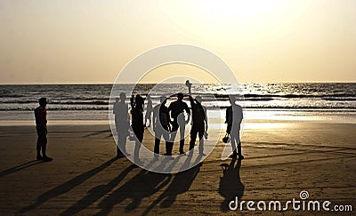 A group of friends silhouetted at Arambol Beach, North Goa Stock Photo