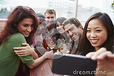 Group Of Friends Taking Photograph At Outdoor Rooftop Bar Stock Photo