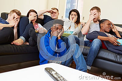 Group Of Friends Watching Television At Home Together Stock Photo