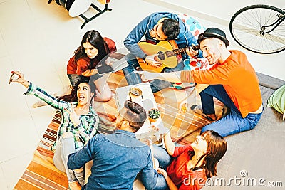Group of funny friends enjoying together playing music with guitar and taking selfie with mobile phone Stock Photo