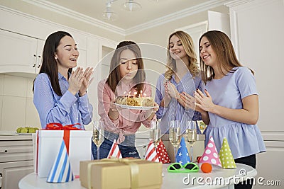 A group of girlfriends with a cake with candles celebrate a birt Stock Photo