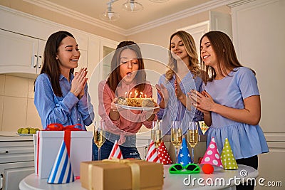 A group of girlfriends with a cake with candles celebrate a birt Stock Photo