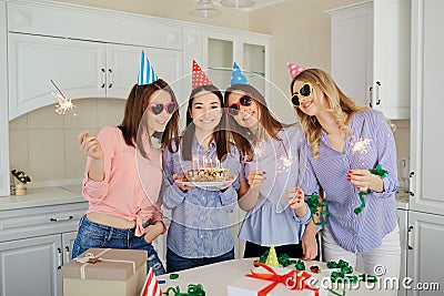 A group of girlfriends with a cake with candles celebrate a birt Stock Photo