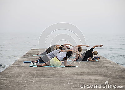 Group of girls doing exercises on the beach. Editorial Stock Photo