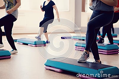 Group of girls is engaged in a step on the stand - fitness. Stock Photo