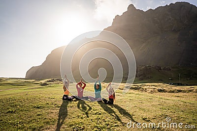 A group of girls meditate at sunset Stock Photo