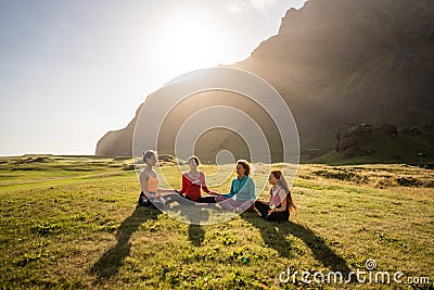 A group of girls meditate at sunset Stock Photo