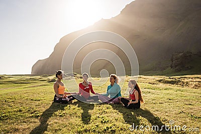 A group of girls meditate at sunset Stock Photo