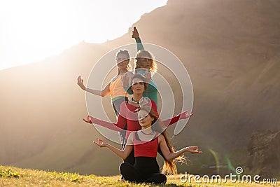 A group of girls meditate at sunset Stock Photo