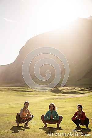 A group of girls meditate at sunset Stock Photo