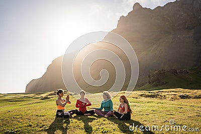 A group of girls meditate at sunset Stock Photo