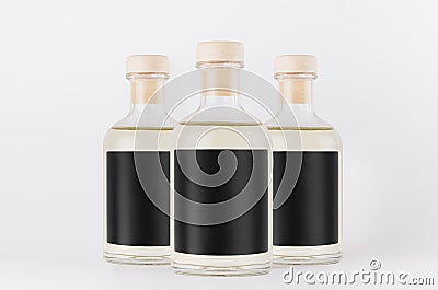 Group glass bottles for cosmetic, perfume, alcohol drink with black label, cork, yellow liquid on white background, mock up. Stock Photo