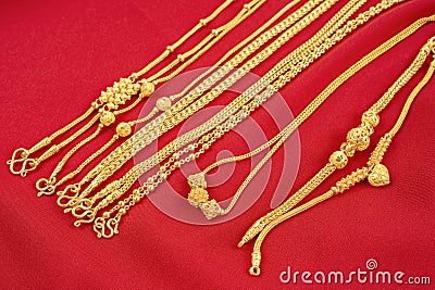 The Group of gold necklaces on red velvet fabric Stock Photo