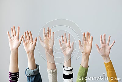 Group of hands raised on grey background Stock Photo