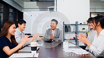 Group of happy Asian business people discuss together in team brainstorm meeting and clap hand, work late night in office Stock Photo