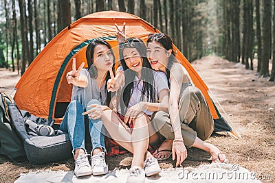 Group of happy Asian teenage girls doing victory pose together, camping by the tent. Outdoor activity, adventure travel concept Stock Photo