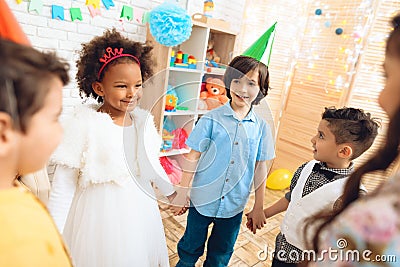 Group of happy children dancing round dance on birthday party. Concept of children`s holiday. Stock Photo