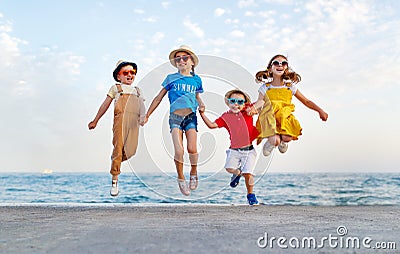 Group of happy children jump by sea in summer Stock Photo