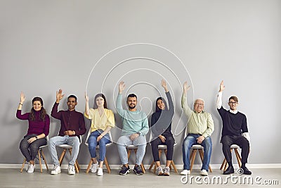 Group of happy diverse people raising hands unanimously voting for suggested idea Stock Photo