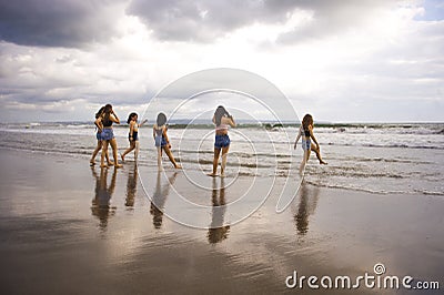 Group of happy and excited young women enjoying having fun on beautiful sunset beach in girlfriends summer holidays trip together Stock Photo