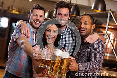 Group of happy friends clinking with beer in pub Stock Photo