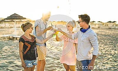 Group of happy friends millennial having fun at beach party drinking fancy cocktails at sunset - Summer joy and friendship Stock Photo