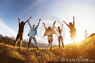 Group happy friends mountains sunset raised arms Stock Photo