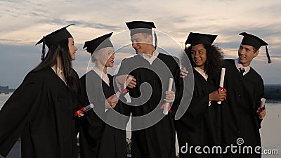 Group of happy graduates walking to graduation ceremony in the e Stock Photo