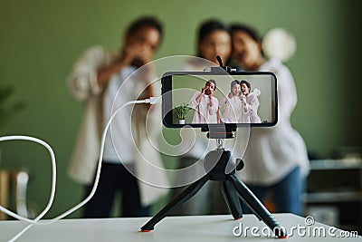 Group of happy intercultural kids performing song on smartphone screen Stock Photo