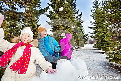 Group of happy kids throw snowballs during fight Stock Photo