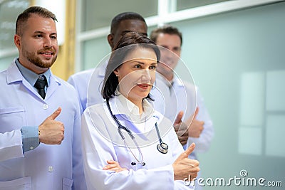 Group Of Happy multicultural doctors showing thumbs up and smiling. Portrait of multiracial medical specialists in white lab coats Stock Photo