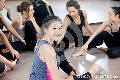 Group of happy sporty young women chatting on break in sports gym Stock Photo