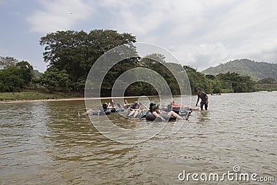 A group of happy tourist relaxing sailing over a blacklifebuoy at Palomino river Editorial Stock Photo