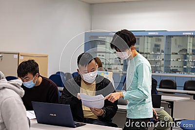 15 11 2021 group of happy young boys and girls with face mask work, discuss, study on assignment and teaching materials together Editorial Stock Photo