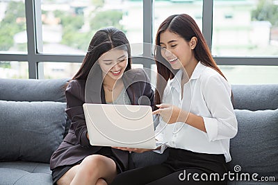 Group of happy young business woman working together with laptop computer on sofa in lobby meeting room.teamwork of two asian girl Stock Photo