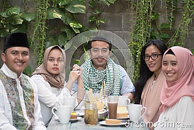 Group of happy young muslim having dinner outdoor looking to cam Stock Photo