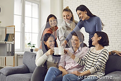 Group of happy young women drinking coffee, laughing and enjoying fun time together Stock Photo