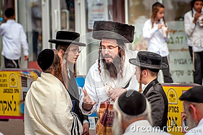 A group of Hasidim pilgrims in traditional clothing emotionally talk. Rosh hashanah holiday, Jewish New Year. Editorial Stock Photo