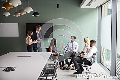 Group Having Discussion At Graduate Recruitment Assessment Day Whilst Being Observed By Recruitment Team Stock Photo