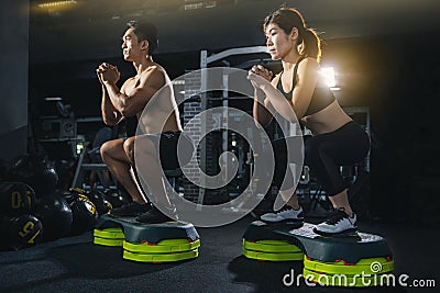 Group of healthy fitness people in gym, Young couple is working out at gym, Attractive woman and handsome muscular man are trainin Stock Photo