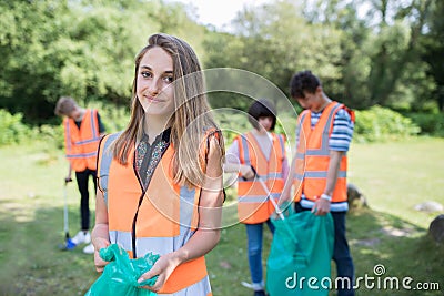 Group Of Helpful Teenagers Collecting Litter In Countryside Stock Photo