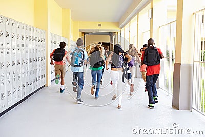 Group Of High School Students Running Along Corridor Stock Photo