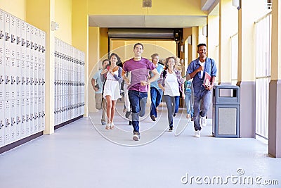 Group Of High School Students Running In Corridor Stock Photo