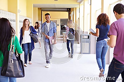 Group Of High School Students Walking Along Hallway Stock Photo