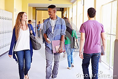 Group Of High School Students Walking Along Hallway Stock Photo