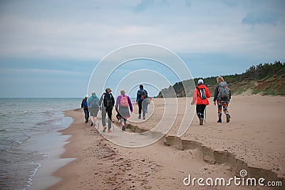 Group of hikers on the sandy coastline of Baltic sea Editorial Stock Photo