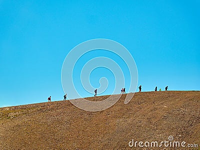 Group of hikers walking on a mountain uphill in summer Editorial Stock Photo