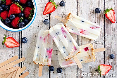 Mixed berry yogurt popsicles over a white wood background Stock Photo