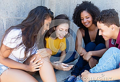 Group of international young adult playing game with mobile app Stock Photo